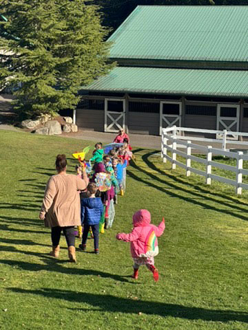 Children walking down a grassy hill